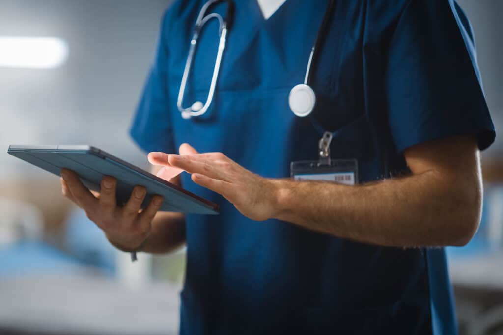 Close up of hospital professional using a tablet, representing the HCA Healthcare data breach.