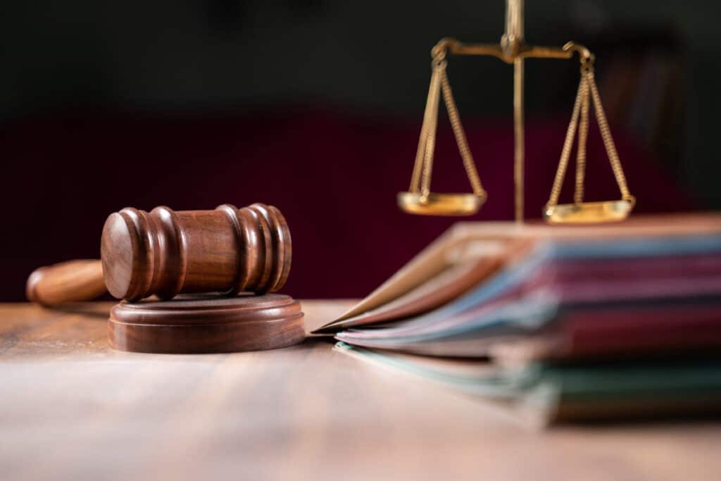 Close up of judge gavel, justice scale, and legal documents on a table, representing the Supreme Court's student loan forgiveness ruling.