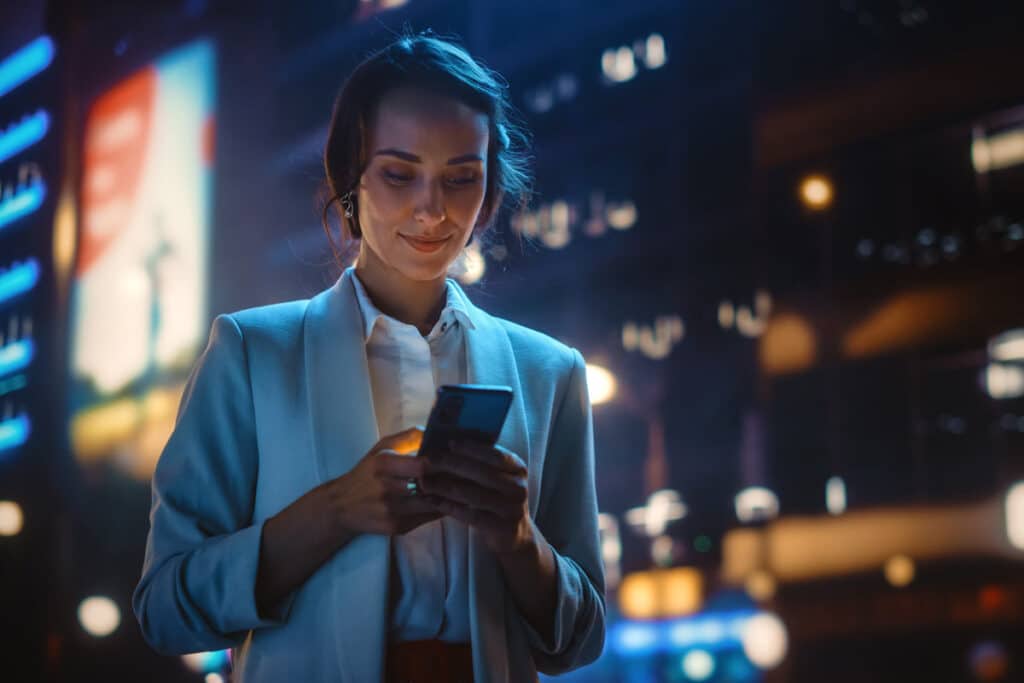 A woman using her smartphone in the city, representing the artificial intelligence class action lawsuit.