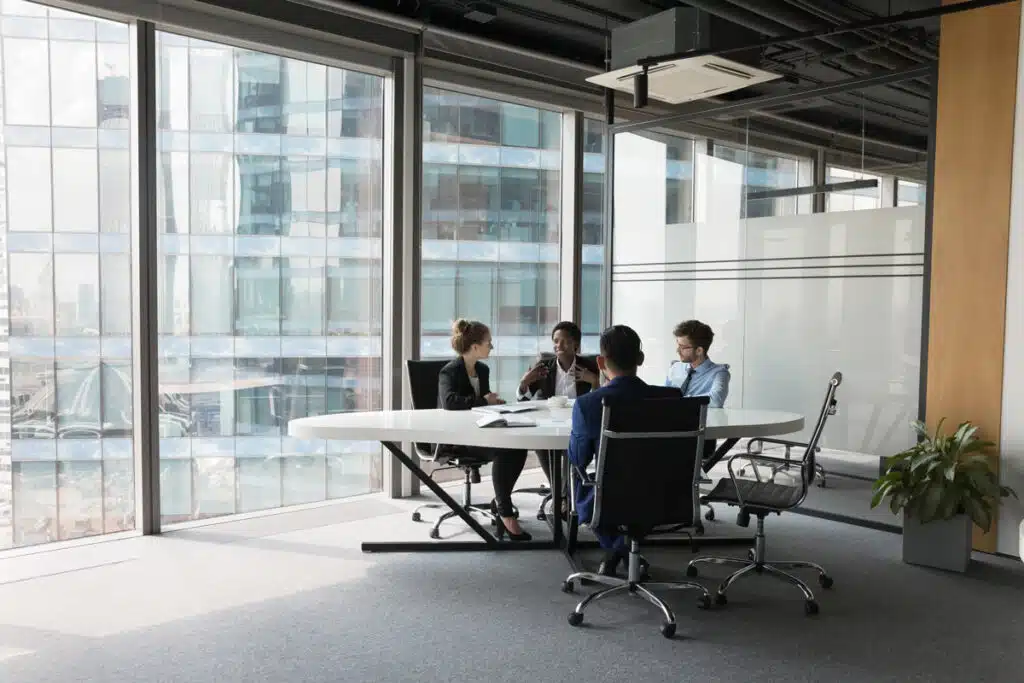 A group of workers working at a table, representing record low unemployment rates.