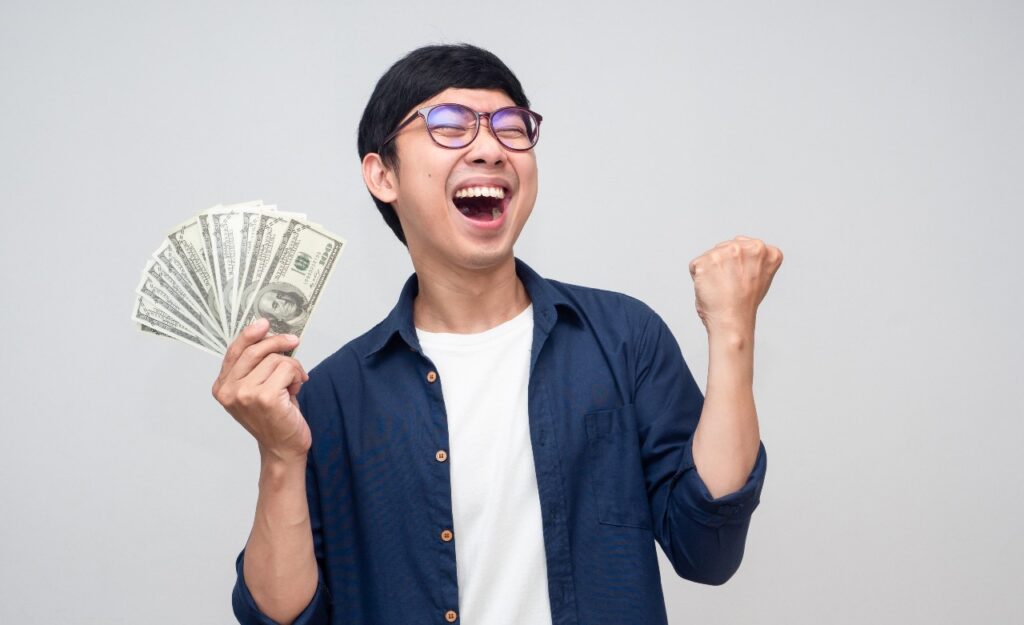 Happy man with cash in hand, representing settlement checks in the mail.