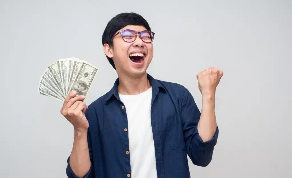 Happy man with cash in hand, representing settlement checks in the mail.