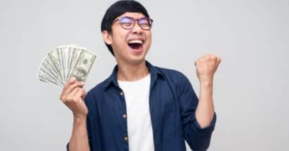 Happy man with cash in hand, representing settlement checks in the mail.