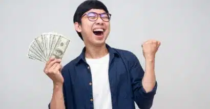 Happy man with cash in hand, representing settlement checks in the mail.