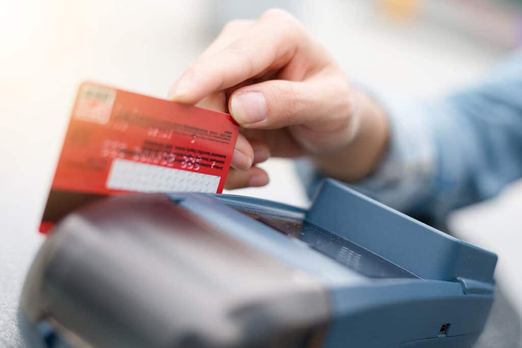 Close up of a debit card being swiped, representing the NetSpend prepaid debit cards refund money FTC settlement.