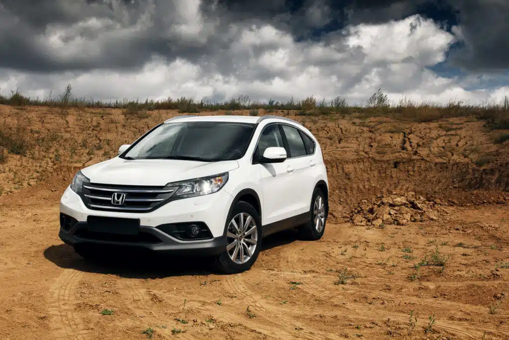 A white Honda CR-V driving through the desert, representing the Honda Variable Timing Control defect class action.