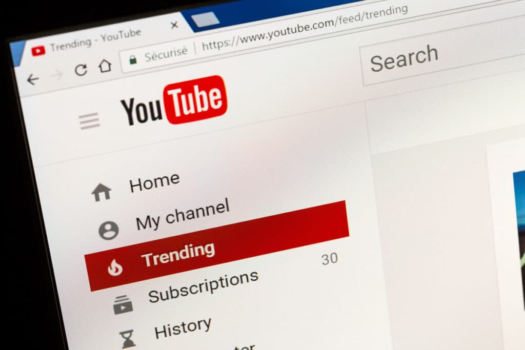 YouTube homepage displayed on a laptop screen, representing the FTX disaster class action lawsuit. YouTube star Brian Jung is facing a $1 billion class action lawsuit for allegedly promoting the sale of FTX yield-bearing accounts without disclosing in any of his YouTube or social media posts that he was paid by FTX.