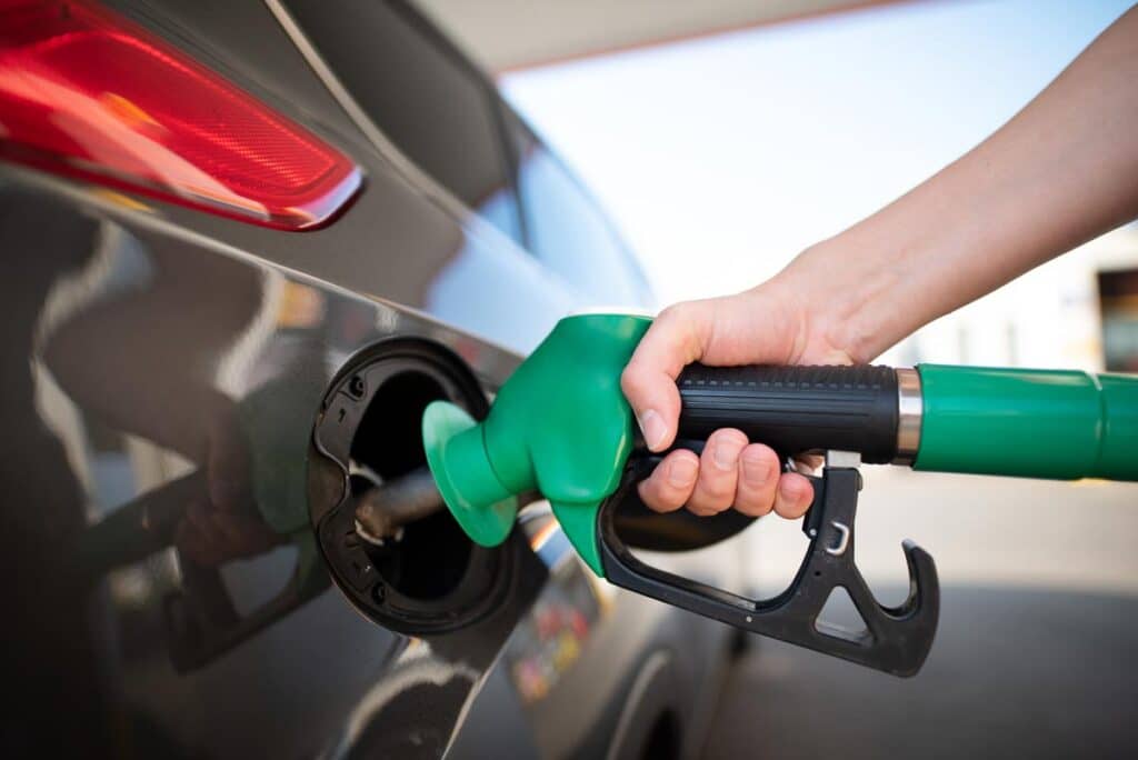 Close up of man pumping gas into his vehicle, representing recent gas station class action lawsuits.