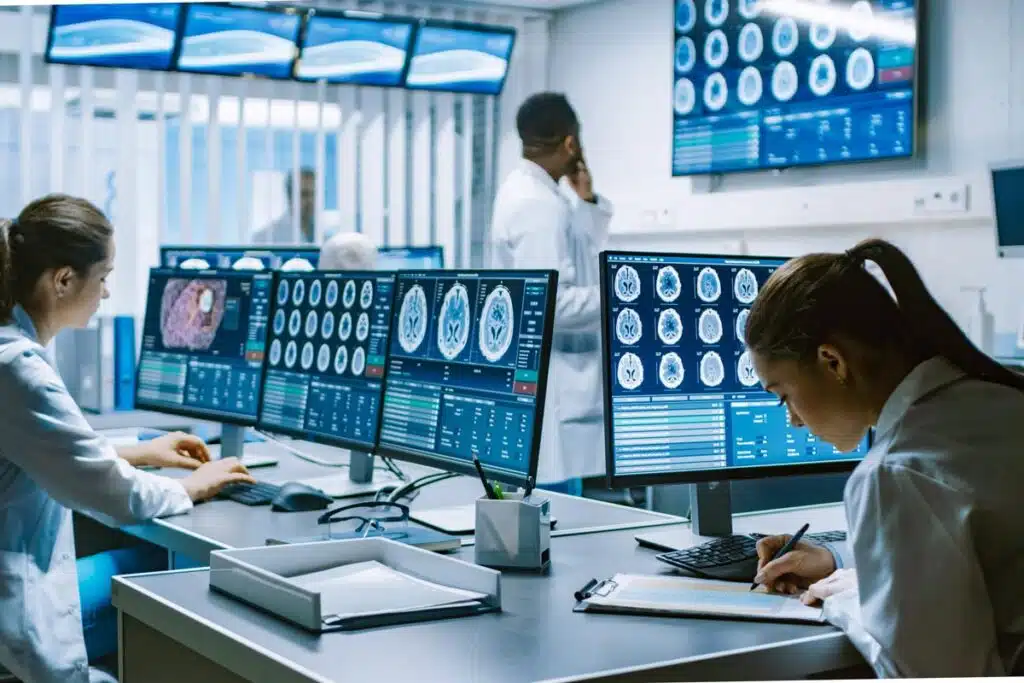 Medical professionals using various devices, representing the TTEC data breach settlement.