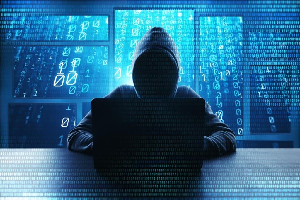 Hooded hacker using a laptop, representing the Hospitality Staffing Solutions class action lawsuit.