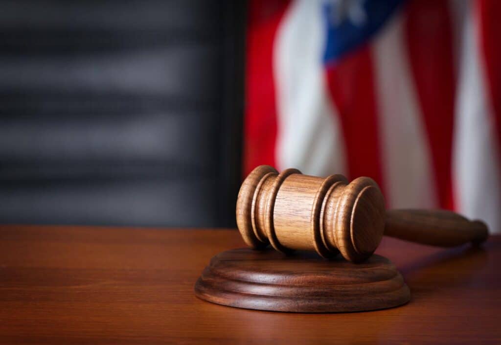 Gavel on a desk with a flag in the background, representing the employment discrimination lawsuits ruling.