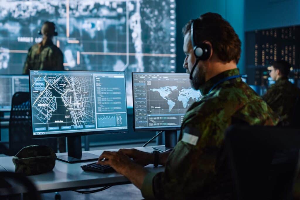 Military surveillance officer working in a communications center, representing Biden’s restrictions on US involvement in China technology.