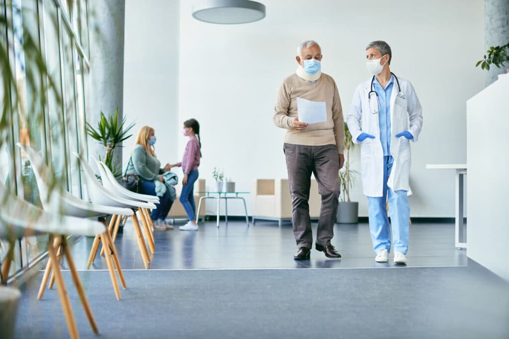 Doctor walking with a patient in a hospital, representing the Iowa Board of Regents settlement.