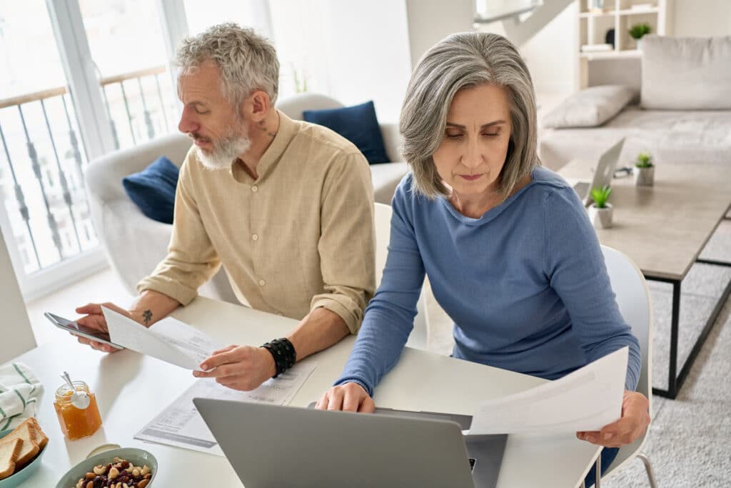 Elderly stressed couple looking at documents, representing the Hometrust Mortgage data breach class action lawsuit settlement.