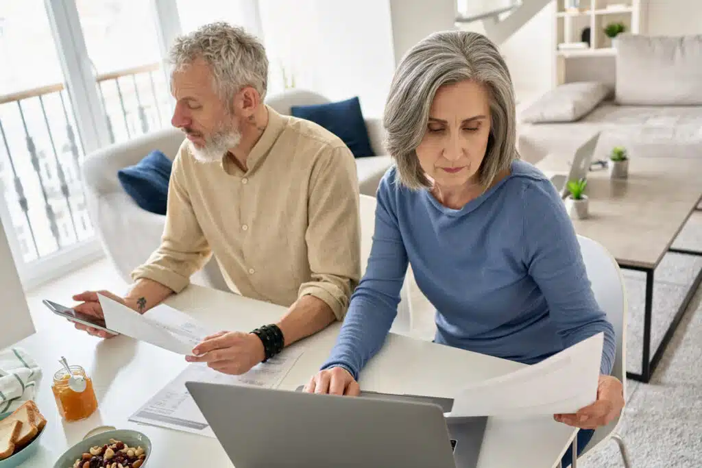 Elderly stressed couple looking at documents, representing the Hometrust Mortgage data breach class action lawsuit settlement.