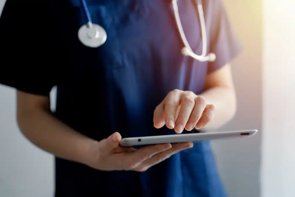 Close up of a nurse using a tablet, representing health care data breaches.