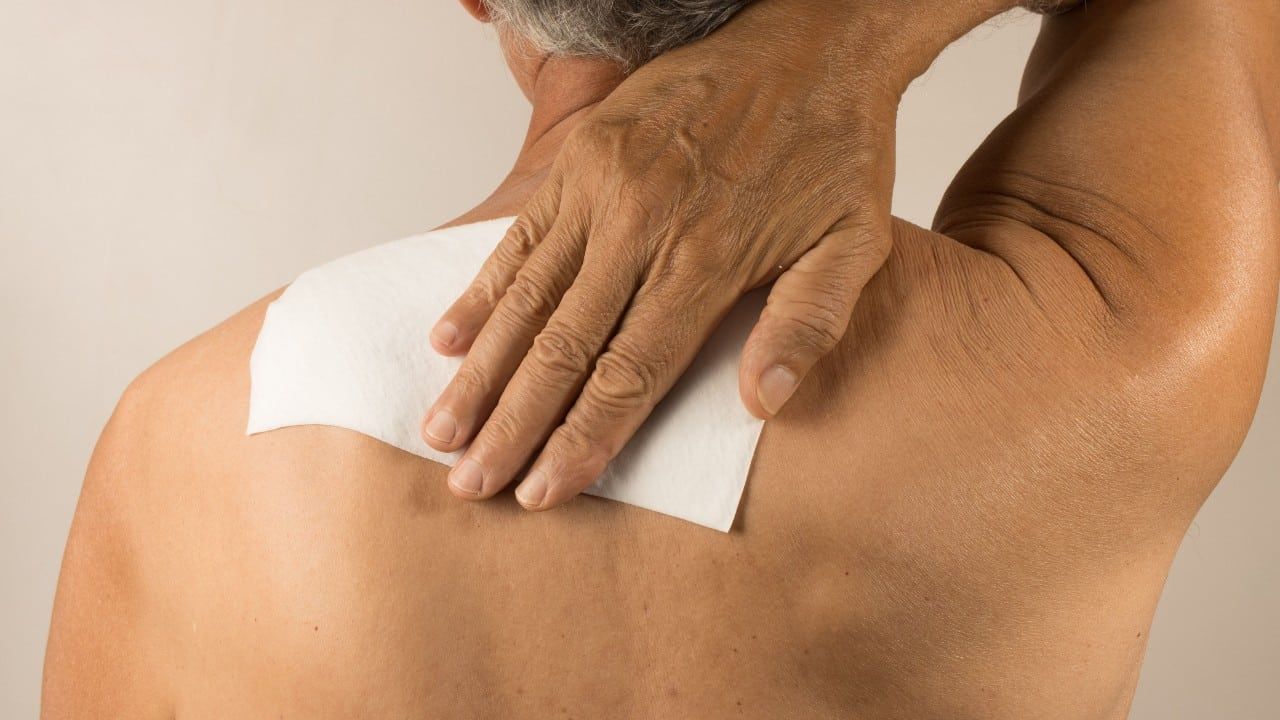 Man wearing a medicated patch for pain