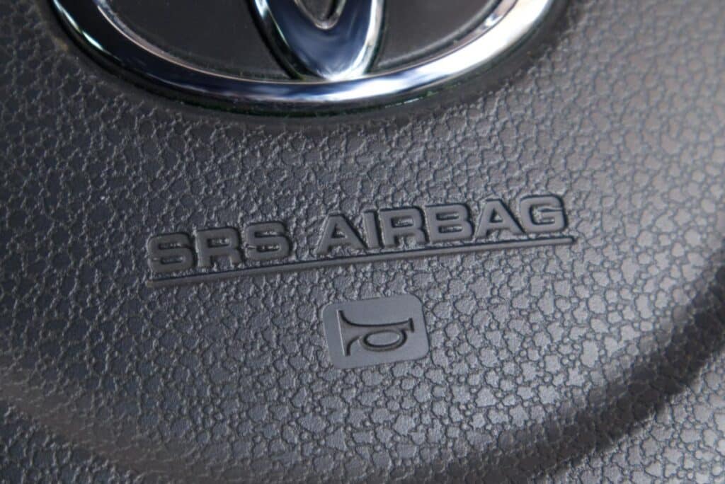 Close up of air bag text on a Toyota steering wheel, representing the Toyota air bag control unit class action lawsuit settlement.