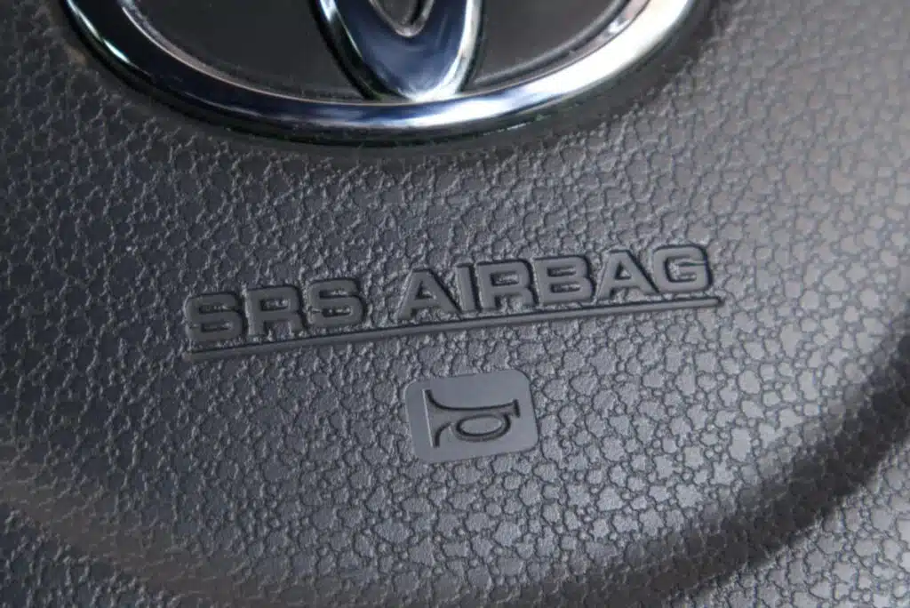 Close up of air bag text on a Toyota steering wheel, representing the Toyota air bag control unit class action lawsuit settlement.