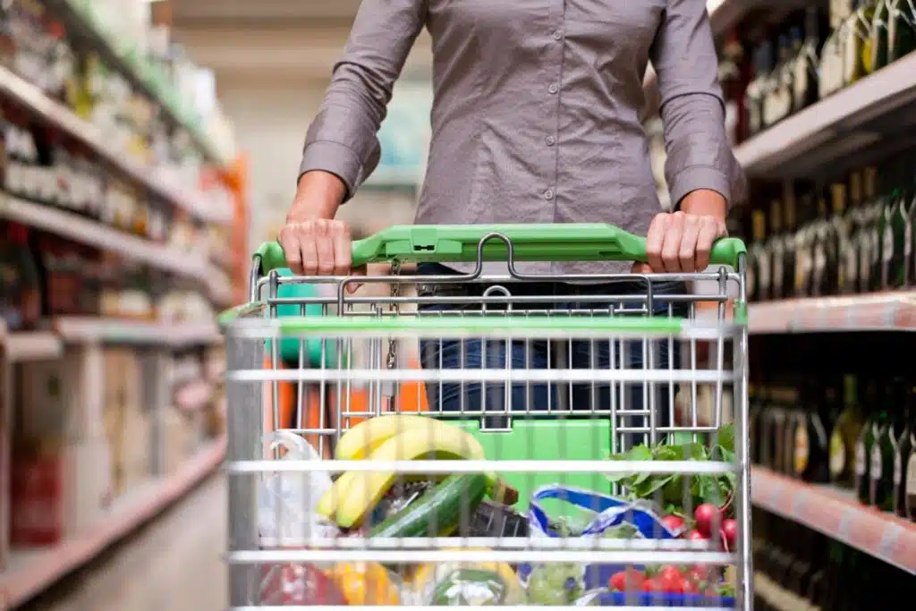 Close up of a woman pushing a cart in a grocery store, representing top recalls for the week of Aug. 7.