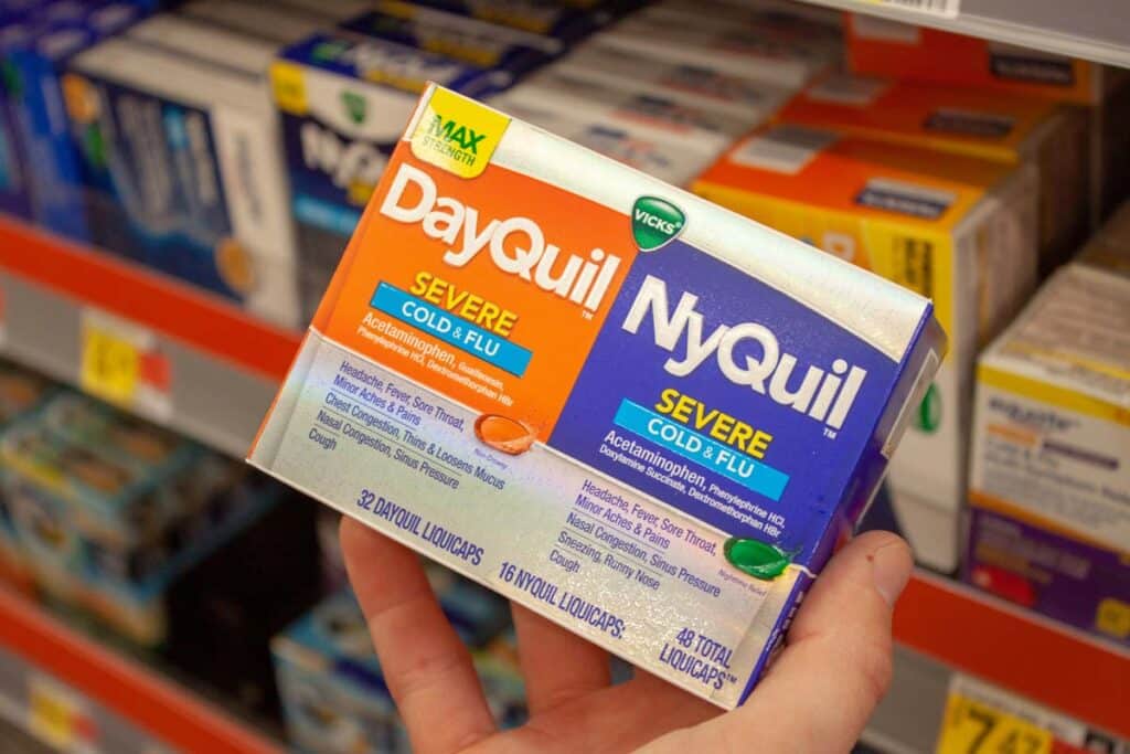 Close up of a hand holding Vicks Dayquil/Nyquil product, representing the P&G Vicks class action.