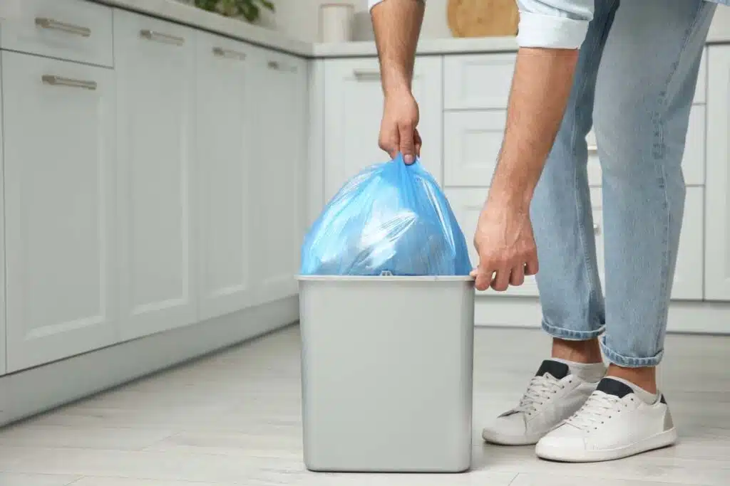 Close up of a recycling bag being pulled out of a bin, representing the Hefty and Great Value recycling bags class action lawsuit settlement.
