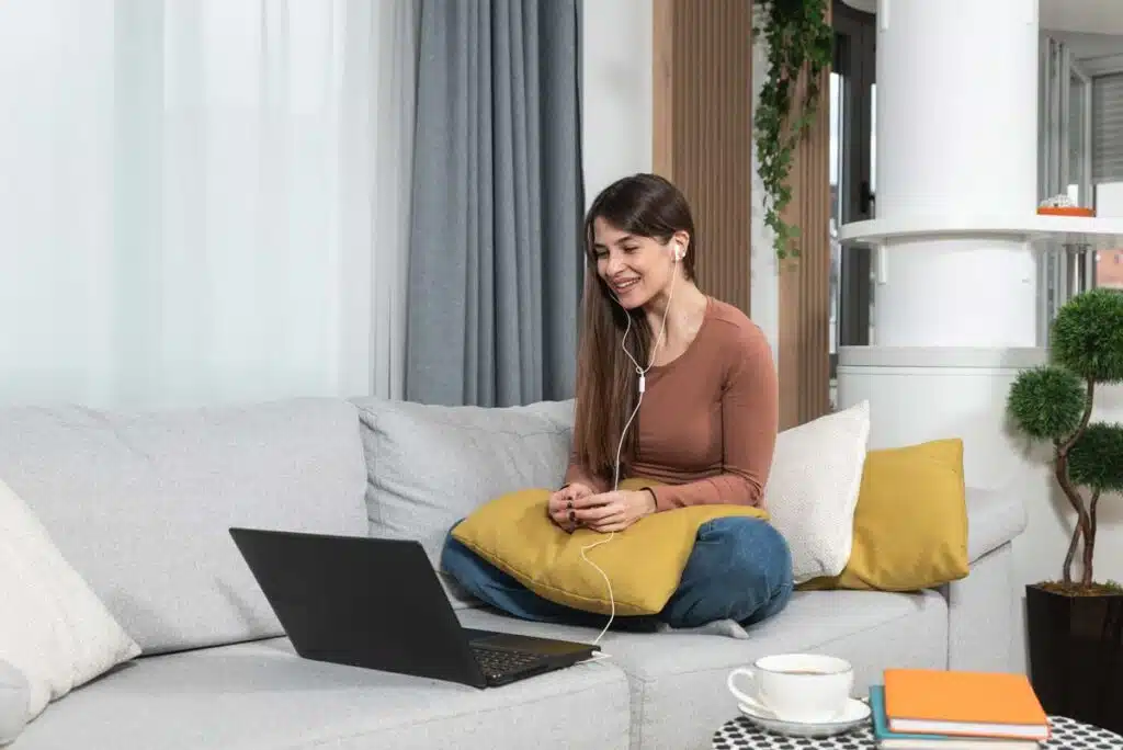 Young woman video chatting with a therapist on her laptop, representing the Headway class action.