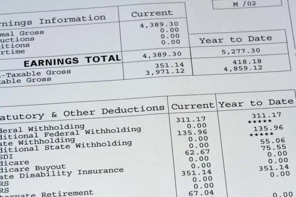 Close up of a paystub, representing the Omnicom 401(k) class action lawsuit settlement.