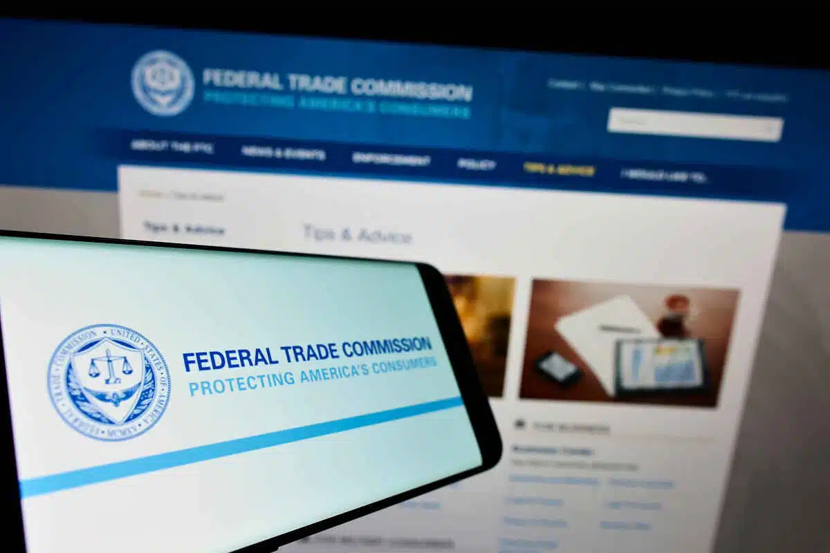 Smartphone with logo of US government agency Federal Trade Commission (FTC) on screen in front of website representing the FTC warning to tax companies.