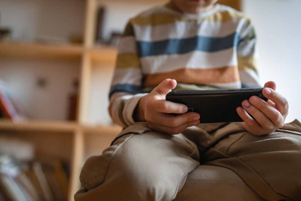 Close up of a child using a smartphone to play a game, representing kids' advertising.