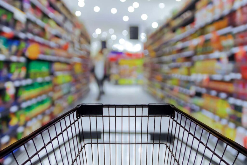 A shopping cart in a grocery store aisle, representing top recalls for the week of Aug. 28.