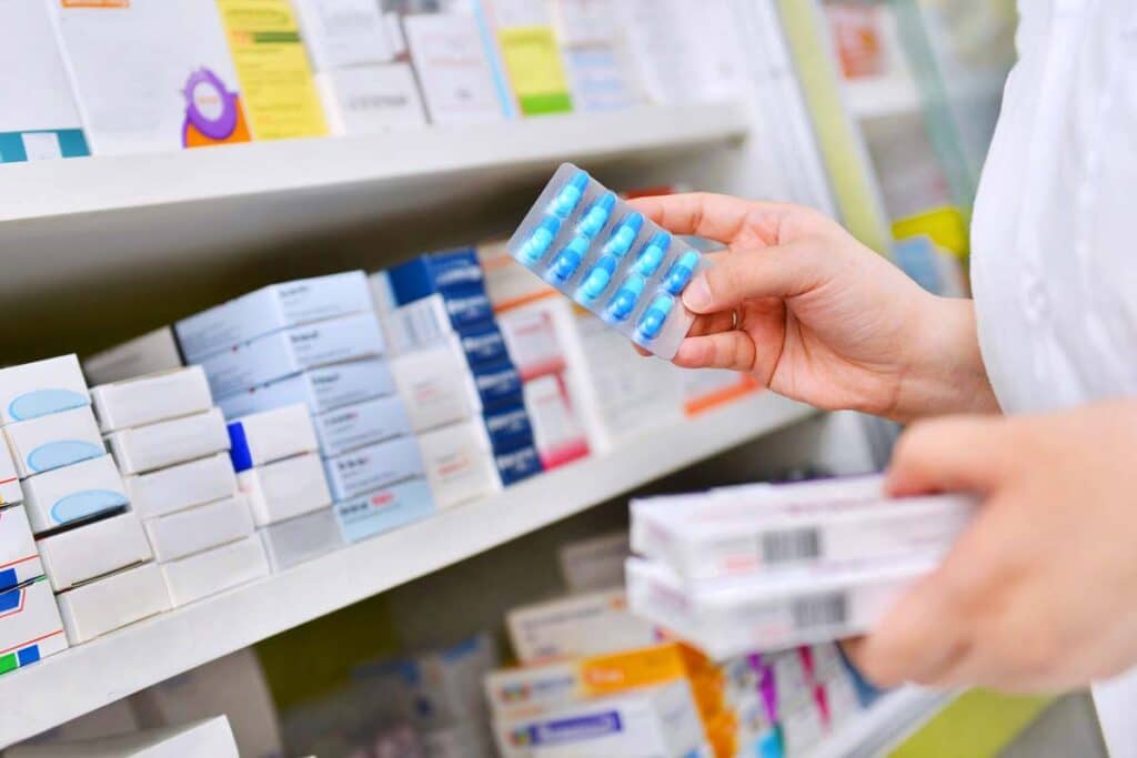 Close up of a pharmacist holding medication, representing recent drug lawsuits and FDA approvals.
