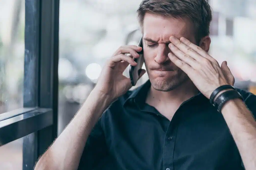A frustrated man talking on the phone, representing the Aegis Financial settlement.
