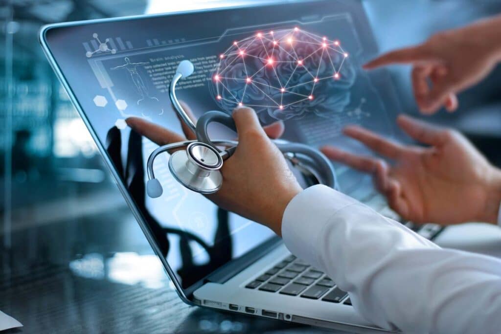 Close up of doctors pointing to a laptop screen displaying intricate health technology, representing the FDA digital health advisory committee.