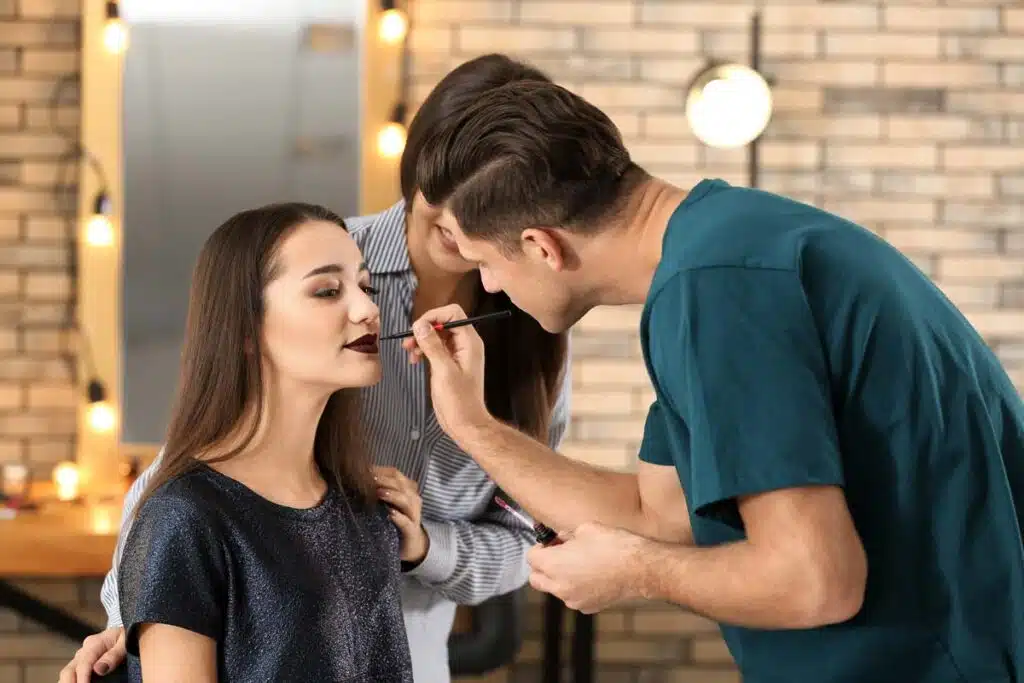 A cosmetology student doing make up on a model, representing the wage-and-hour class action lawsuit settlement with Douglas J. Institute, an Aveda cosmetology school