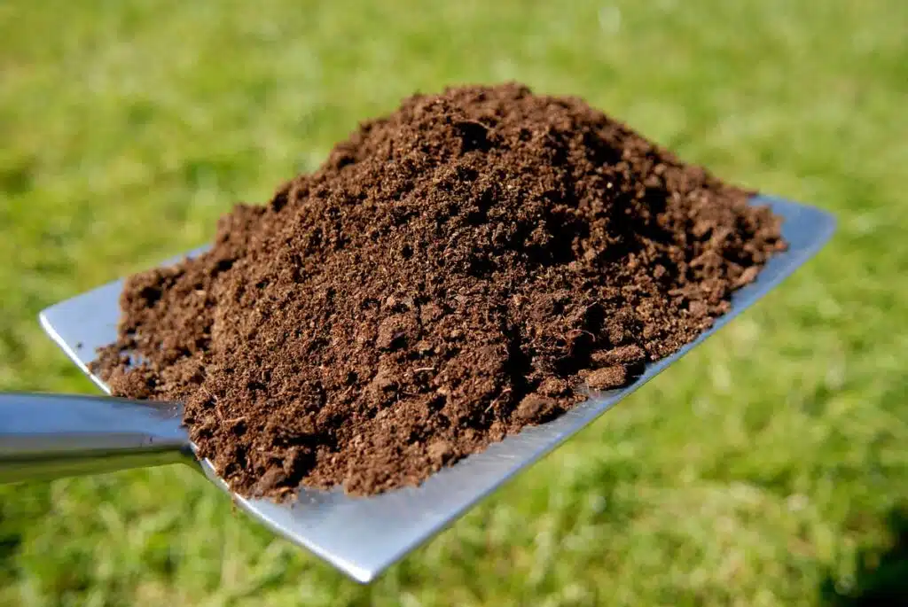 Close up of planting compost on a gardening shovel, representing the Dean Innovations settlement.