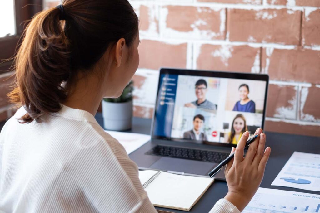 A young woman joining a work virtual meeting with coworkers, representing remote work rates.