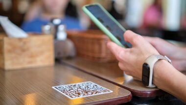 Close up of a hand placing a food mobile order on their smartphone, representing the Arby's and Burger King lawsuit.