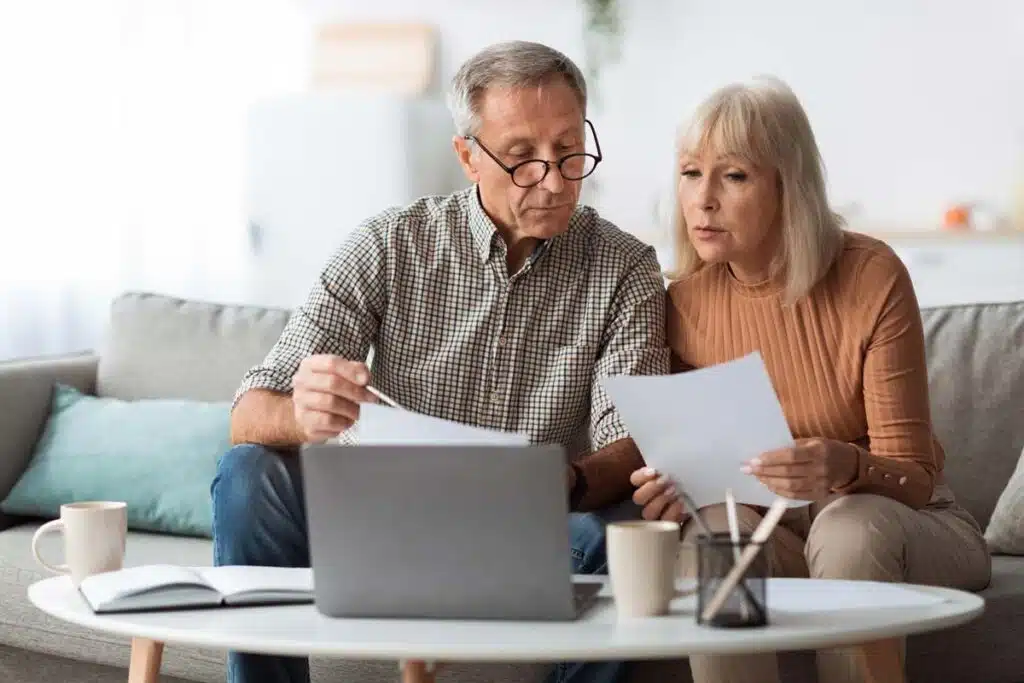 Elderly couple reading a letter, representing the Enhanced Recovery Co. settlement.