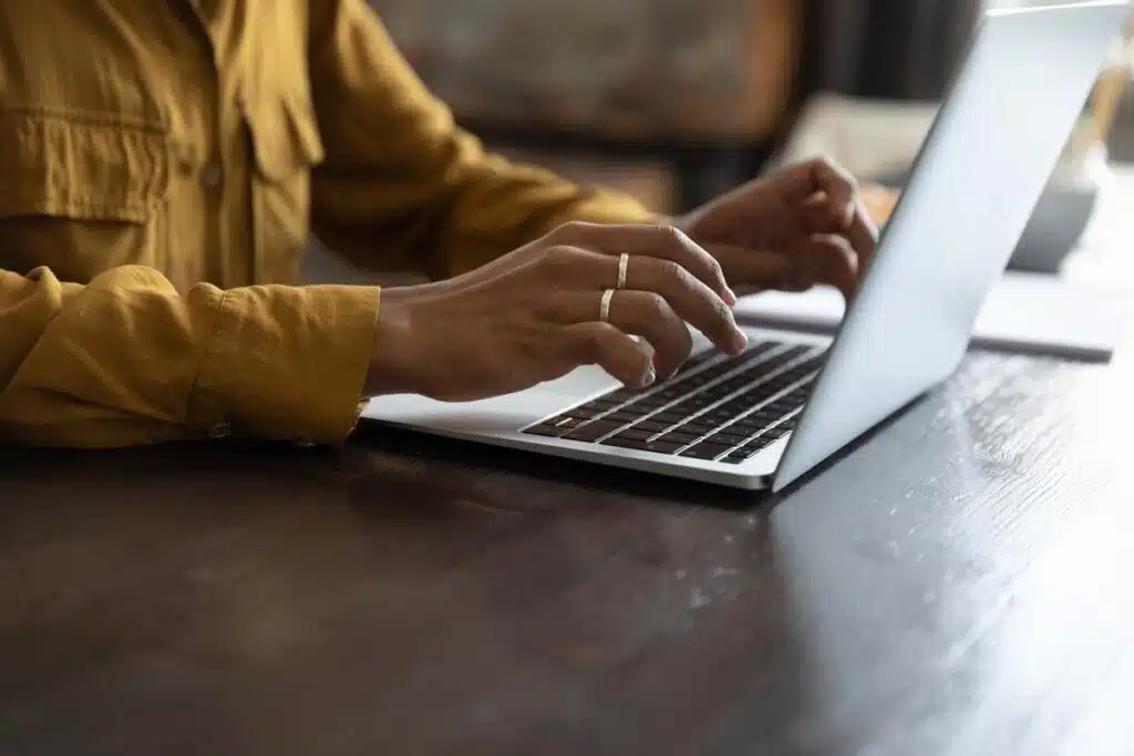 Close up of a woman typing on a laptop, representing the tenantreports.com background reports class action settlement.