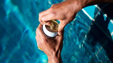 Close up of hands opening a seltzer can by the pool, representing the Vizzy seltzer class action.