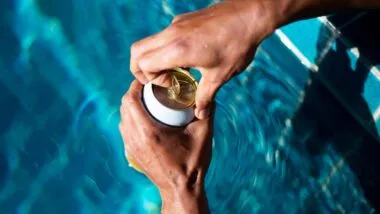 Close up of hands opening a seltzer can by the pool, representing the Vizzy seltzer class action.