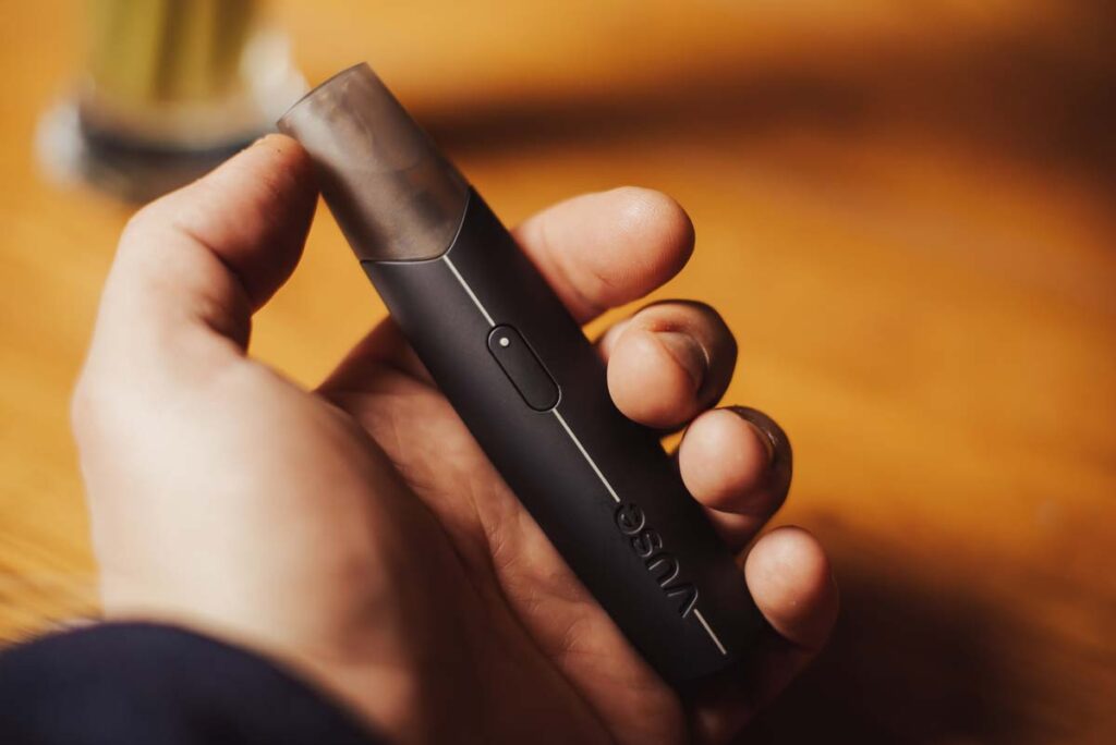 Close up of a mans hand holding a Vuse electronic cigarette device, representing the Vuse FDA ban.