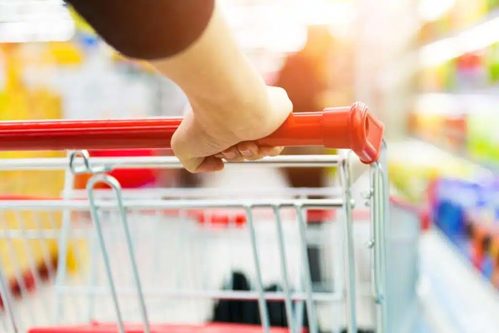 Close up of a womans hands pushing a shopping cart, representing top recalls for the week of Oct. 19.