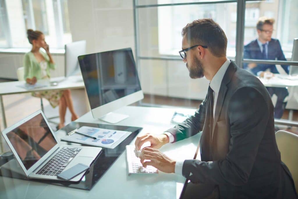 A young businessman uses a computer in his office, representing the Sterling Valley Systems and Inntopia data breach settlement.