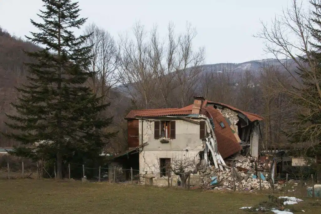 Exterior of a residential home damaged by an earthquake, representing the New Dominion Oklahoma earthquake damage class action settlement.