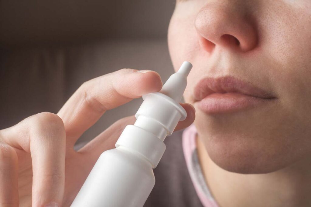 Close up of a woman using a sinus spray, representing the Biomic Sciences nasal spray recall.