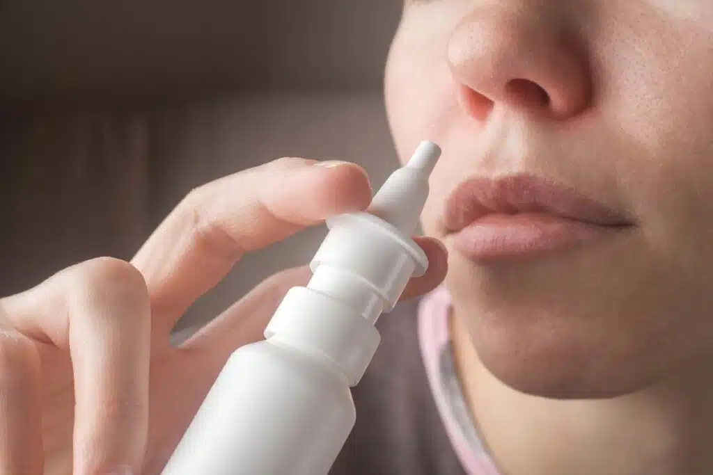 Close up of a woman using a sinus spray, representing the Biomic Sciences nasal spray recall.