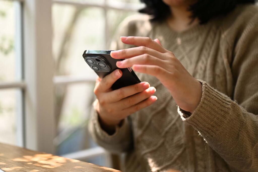 Close up of a womans hands using a smartphone, representing the Brigit lawsuit.