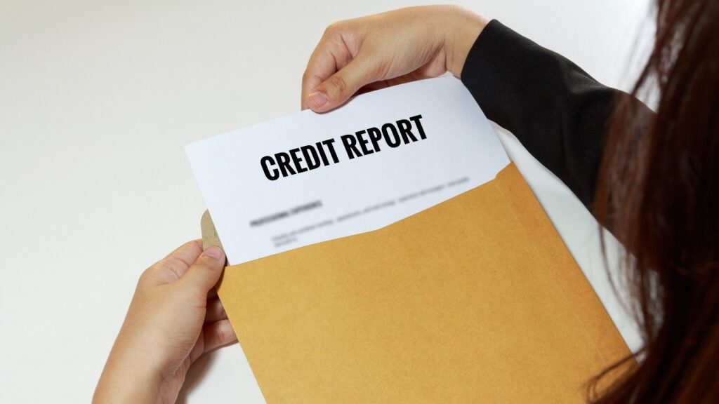 Women pulling credit report papers out of envelope.